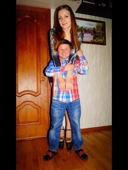 Very small happy man with extremely tall woman in giant heels!